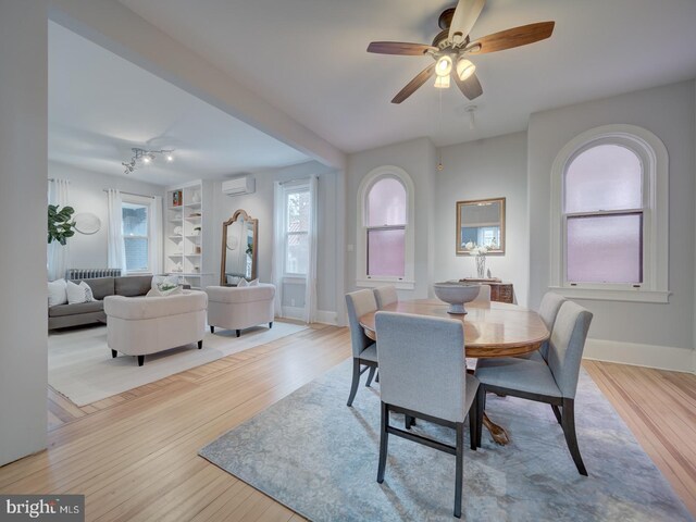 1234 Monroe St NE, Washington, DC 20017 - dining space with an AC wall unit, baseboards, and wood finished floors