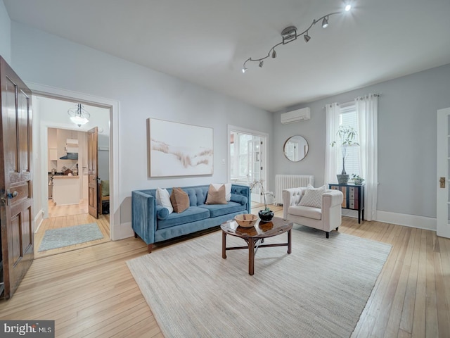 1234 Monroe St NE, Washington, DC 20017 - living area featuring radiator, light wood finished floors, and a wall unit AC