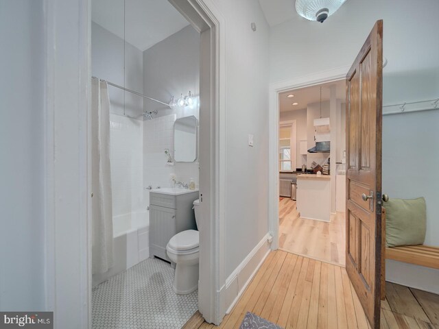 1234 Monroe St NE, Washington, DC 20017 - bathroom featuring toilet, shower / bathtub combination with curtain, a sink, and hardwood / wood-style flooring