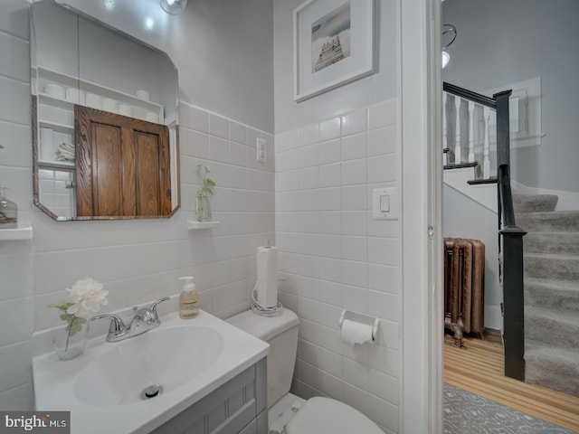 1234 Monroe St NE, Washington, DC 20017 - bathroom featuring toilet, tile walls, radiator heating unit, and wood finished floors