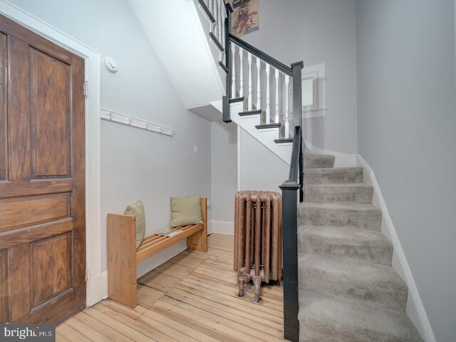 1234 Monroe St NE, Washington, DC 20017 - stairs featuring radiator heating unit, wood-type flooring, and baseboards