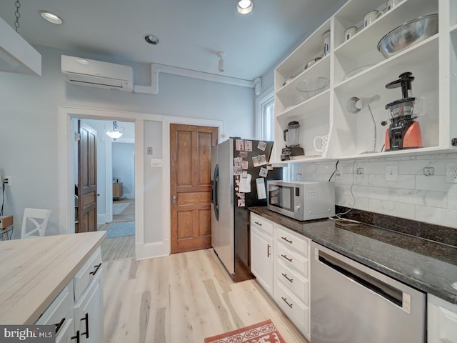 1234 Monroe St NE, Washington, DC 20017 - kitchen with light wood-type flooring, a wall mounted air conditioner, backsplash, open shelves, and appliances with stainless steel finishes