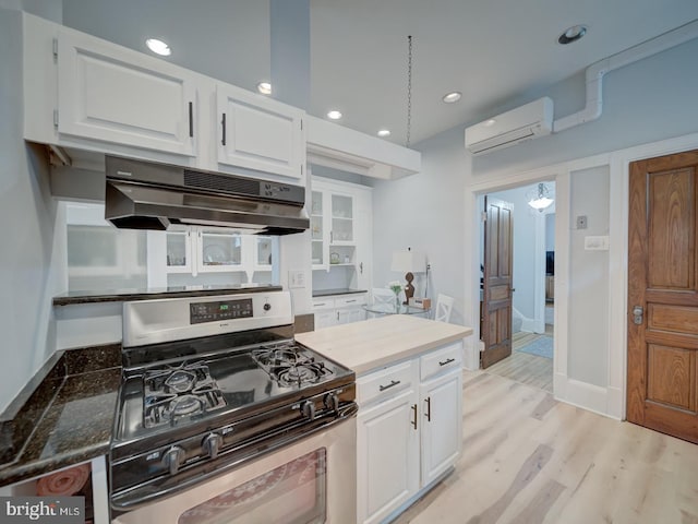 1234 Monroe St NE, Washington, DC 20017 - kitchen featuring light wood-type flooring, a wall unit AC, white cabinets, gas range, and under cabinet range hood