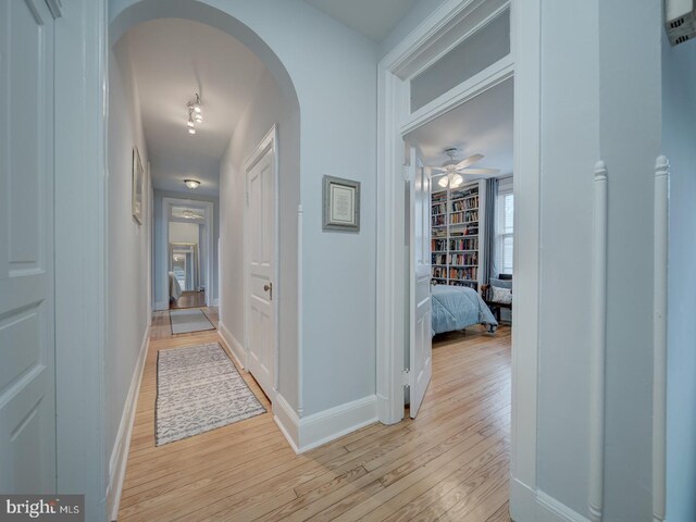 1234 Monroe St NE, Washington, DC 20017 - corridor with baseboards, arched walkways, and light wood-style floors