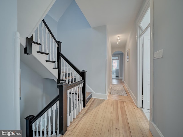 1234 Monroe St NE, Washington, DC 20017 - corridor featuring arched walkways, stairway, baseboards, and hardwood / wood-style floors