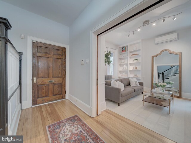 1234 Monroe St NE, Washington, DC 20017 - foyer featuring light wood-style flooring, stairway, baseboards, and a wall unit AC