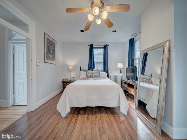 1234 Monroe St NE, Washington, DC 20017 - bedroom with radiator heating unit, light wood-style flooring, baseboards, and ceiling fan