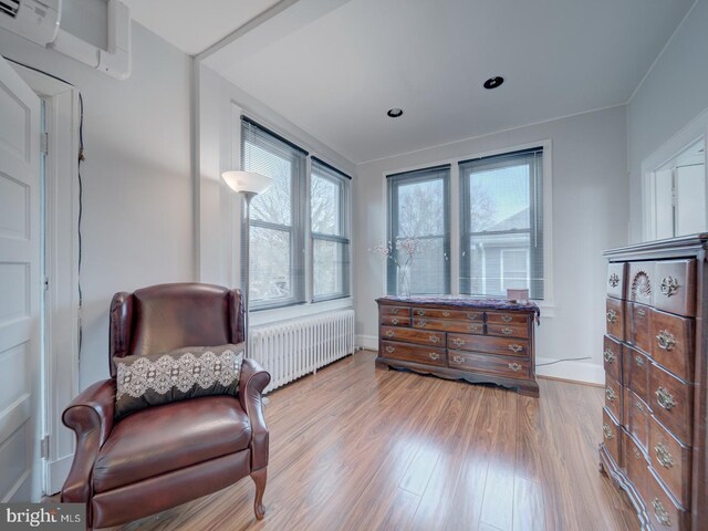 1234 Monroe St NE, Washington, DC 20017 - sitting room with radiator heating unit, a wall mounted AC, plenty of natural light, and wood finished floors