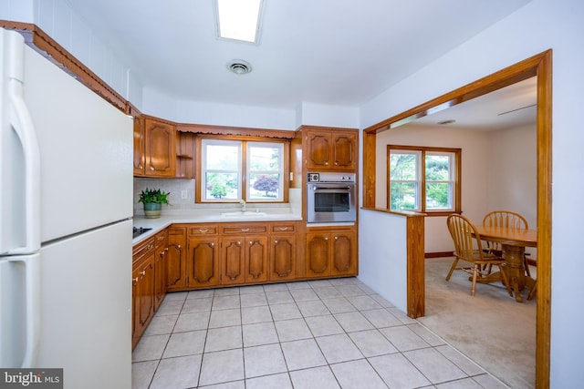 407 Wilgis Rd, Fallston, MD 21047 - kitchen featuring freestanding refrigerator, stainless steel oven, light countertops, and brown cabinets