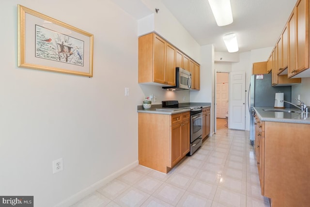 2901 S Leisure World Blvd Unit 133, Silver Spring, MD 20906 - kitchen with appliances with stainless steel finishes, a sink, light floors, baseboards, and light countertops