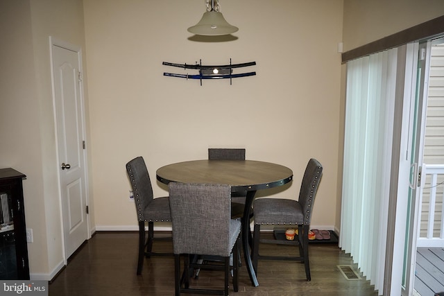 dining space featuring dark wood-style flooring, visible vents, and baseboards