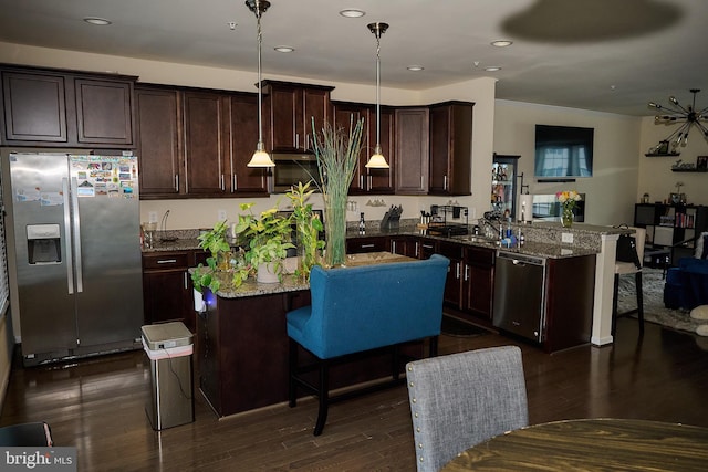 kitchen with stainless steel appliances, dark wood-style floors, dark brown cabinets, and dark stone countertops