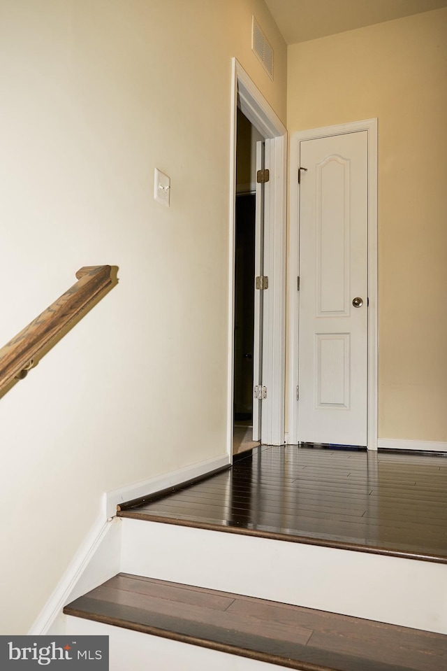 stairway with wood finished floors and visible vents