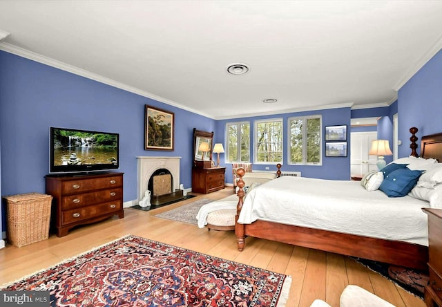 bedroom featuring baseboards, ornamental molding, hardwood / wood-style floors, and visible vents