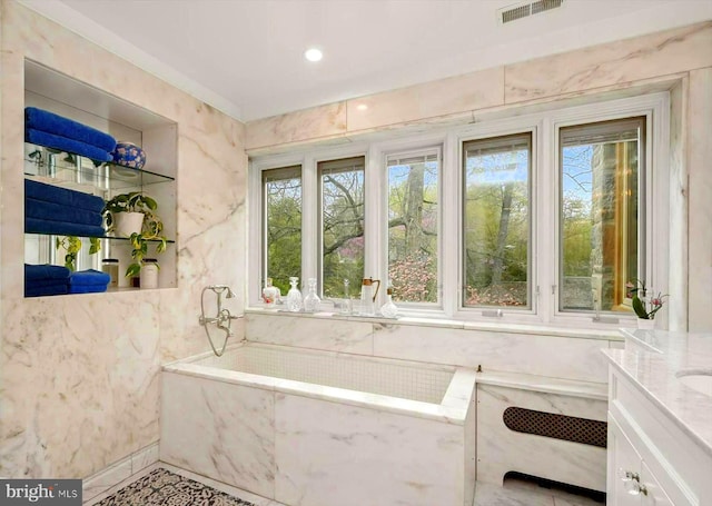 full bathroom featuring visible vents, a bath, and vanity