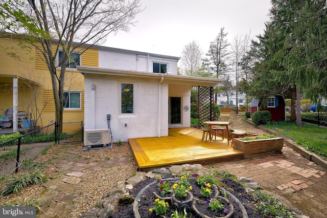 27 Ridge Rd, Greenbelt, MD 20770 - back of house featuring a deck, ac unit, concrete block siding, fence, and an outbuilding