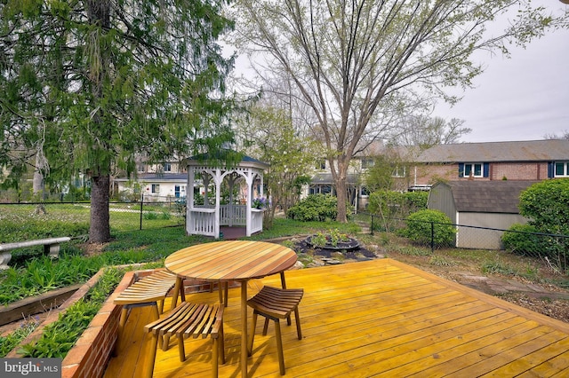 27 Ridge Rd, Greenbelt, MD 20770 - wooden terrace with a gazebo, a fenced backyard, a storage unit, and an outbuilding