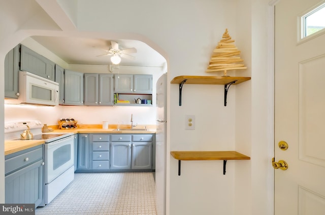 27 Ridge Rd, Greenbelt, MD 20770 - kitchen featuring white appliances, blue cabinetry, a ceiling fan, open shelves, and a sink