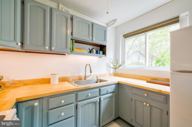 27 Ridge Rd, Greenbelt, MD 20770 - kitchen featuring a sink, open shelves, wooden counters, and freestanding refrigerator