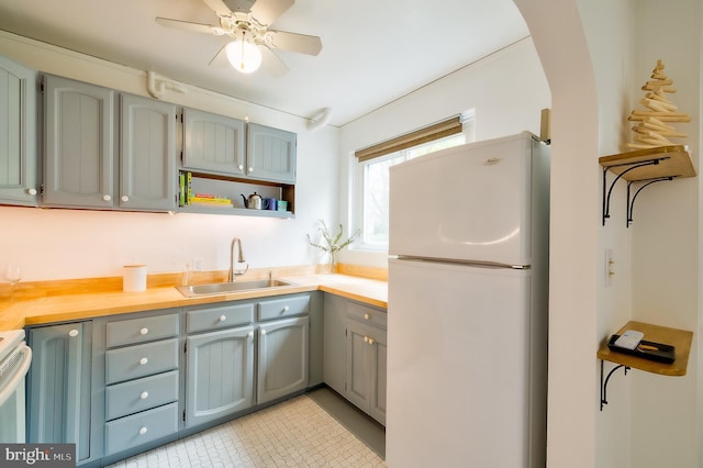 27 Ridge Rd, Greenbelt, MD 20770 - kitchen featuring light countertops, freestanding refrigerator, open shelves, ceiling fan, and a sink