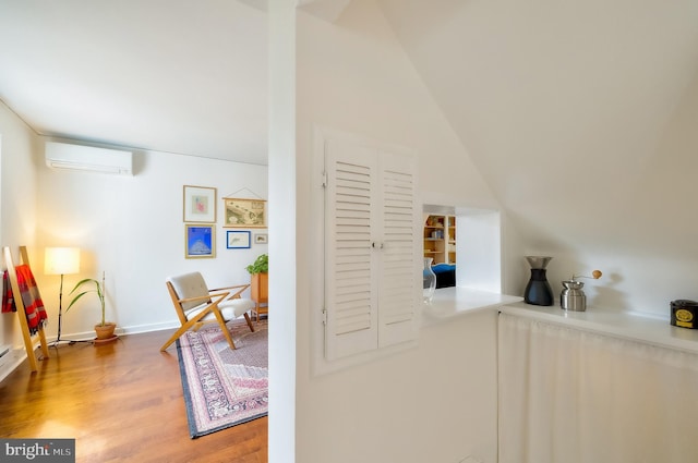 27 Ridge Rd, Greenbelt, MD 20770 - interior space with a wall mounted AC, baseboards, vaulted ceiling, and wood finished floors