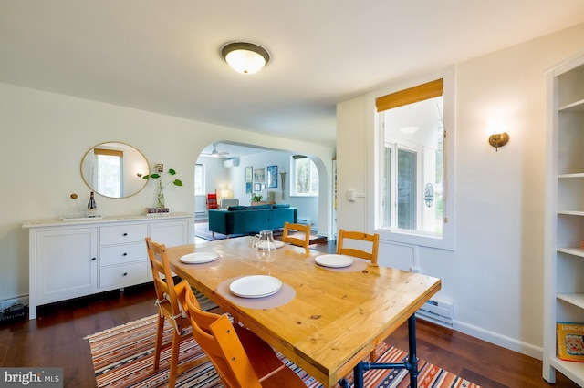 27 Ridge Rd, Greenbelt, MD 20770 - dining space featuring a baseboard heating unit, built in features, baseboards, dark wood finished floors, and arched walkways
