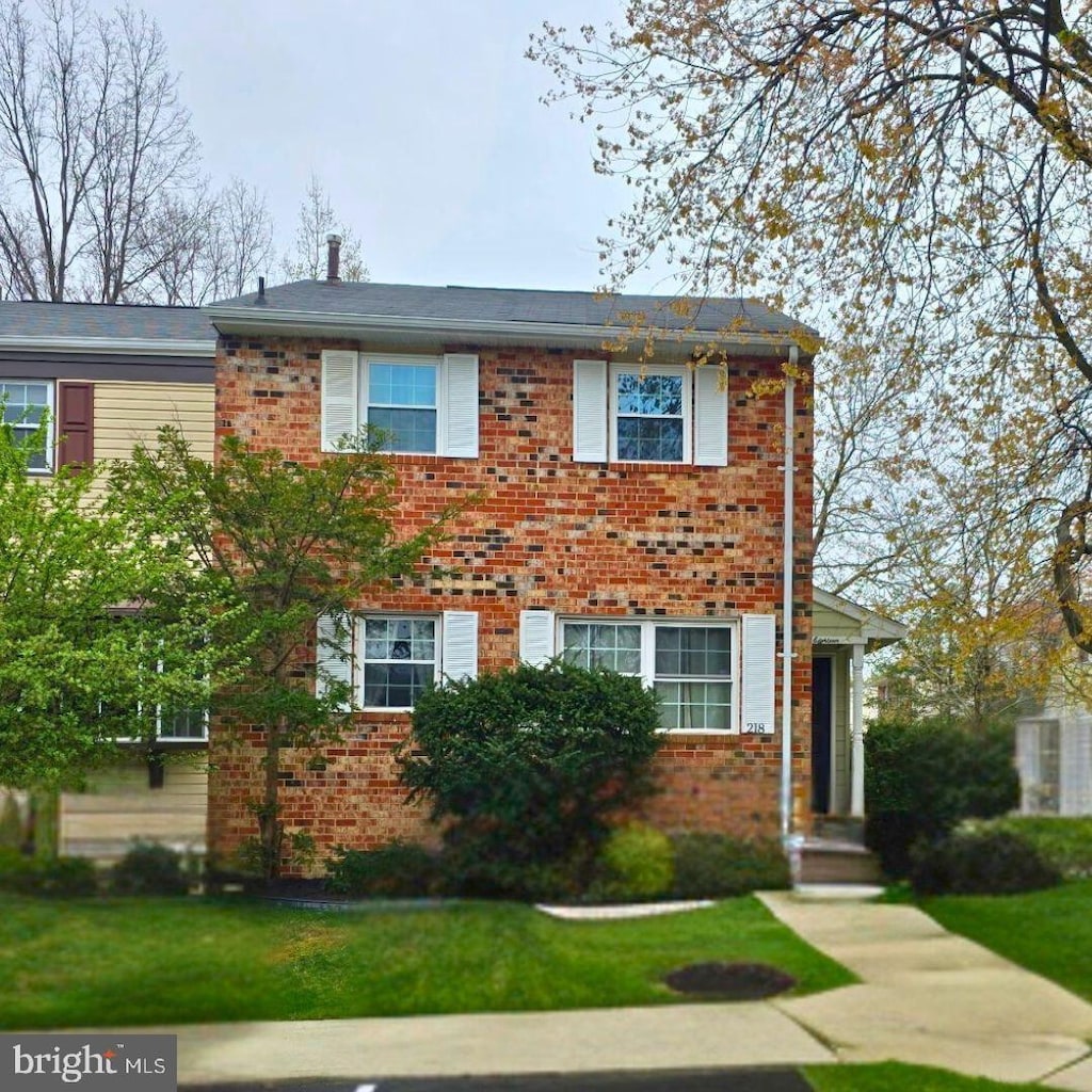 view of front facade featuring brick siding and a front lawn