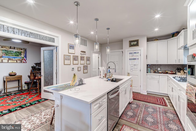 104 Saint Ives Pl Unit 409, Oxon Hill, MD 20745 - kitchen with an island with sink, gas cooktop, white cabinets, stainless steel dishwasher, and a sink