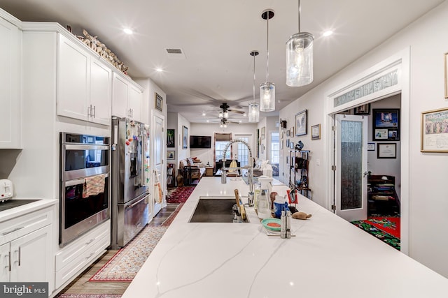 104 Saint Ives Pl Unit 409, Oxon Hill, MD 20745 - kitchen with visible vents, decorative light fixtures, open floor plan, appliances with stainless steel finishes, and white cabinetry
