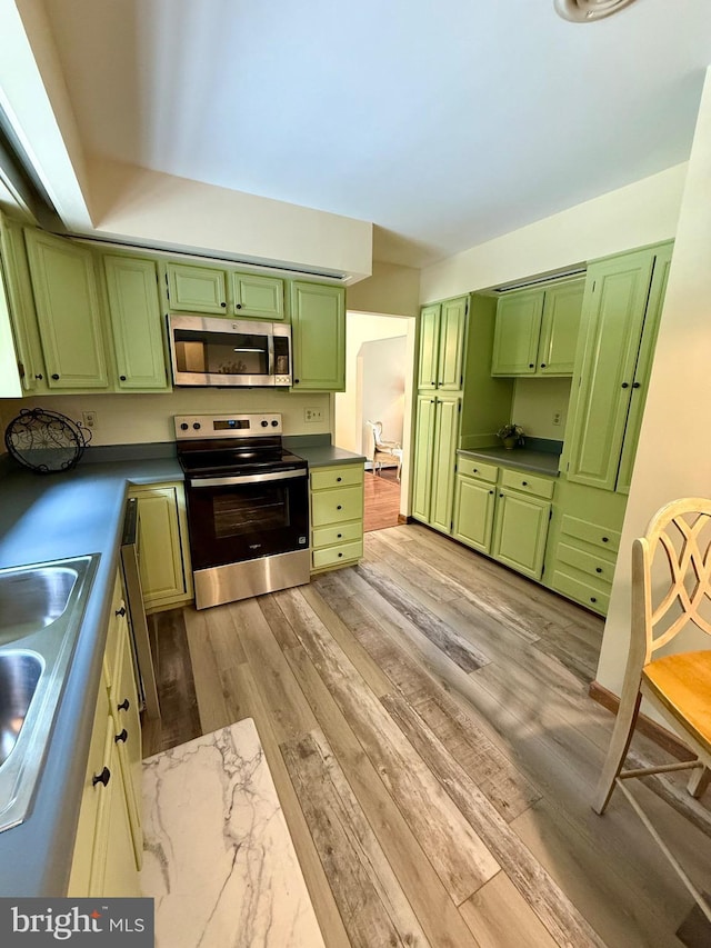 11003 Marty St NW, Lavale, MD 21502 - kitchen with stainless steel appliances, green cabinetry, a sink, and light wood-style flooring