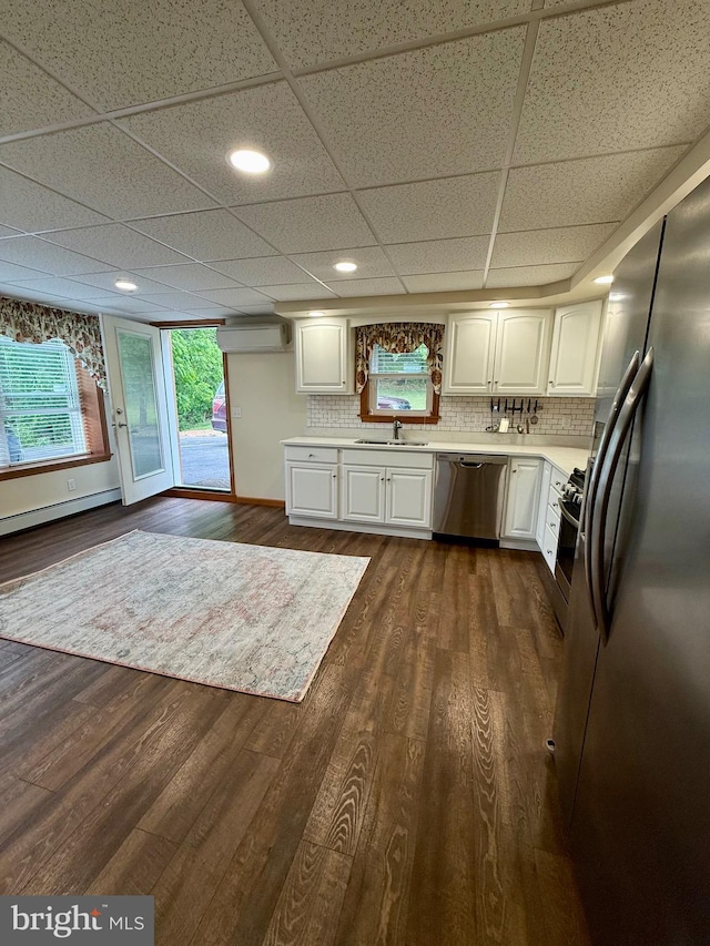 11003 Marty St NW, Lavale, MD 21502 - kitchen featuring appliances with stainless steel finishes, light countertops, white cabinets, baseboard heating, and decorative backsplash