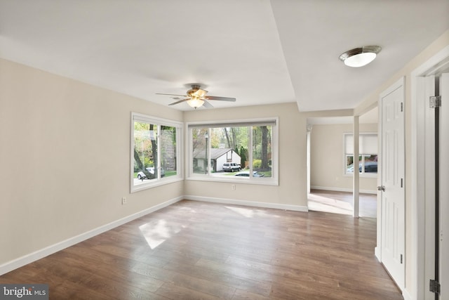 unfurnished room featuring baseboards, a ceiling fan, and wood finished floors