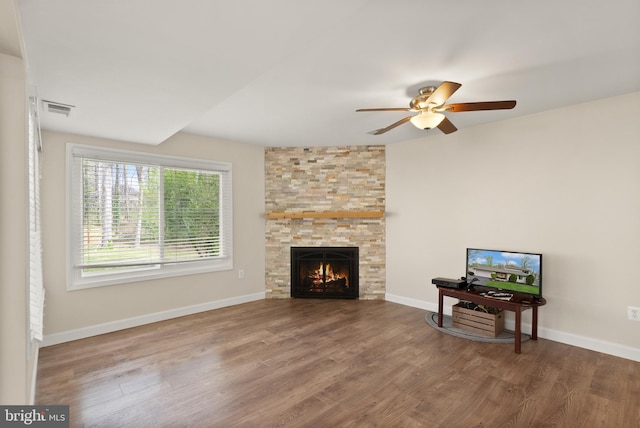 living area featuring ceiling fan, wood finished floors, visible vents, and a fireplace