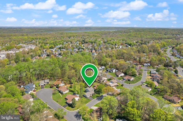 drone / aerial view featuring a residential view and a wooded view
