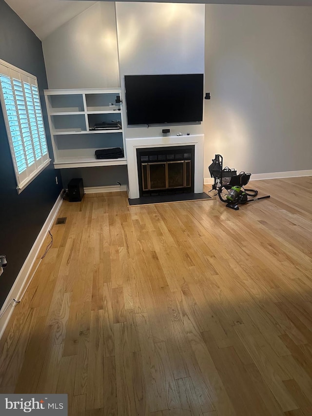 42 Rebecca Ct, Ewing, NJ 08628 - unfurnished living room with visible vents, wood finished floors, baseboards, a fireplace with flush hearth, and vaulted ceiling