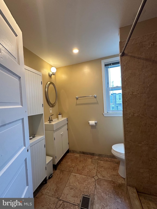 2261 Sidney Ave, Baltimore, MD 21230 - bathroom with toilet, vanity, baseboards, visible vents, and tiled shower