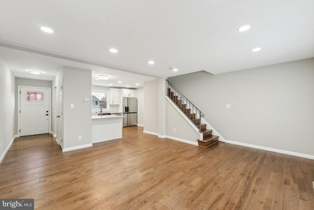 2918 Landover St, Alexandria, VA 22305 - unfurnished living room featuring stairway, baseboards, and light wood-style flooring