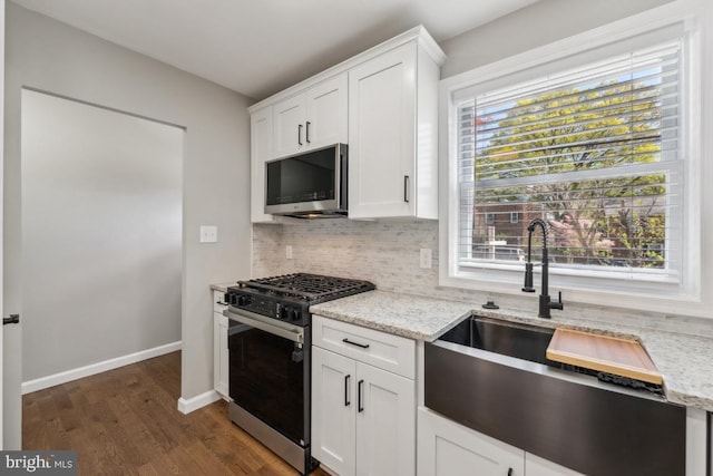 2918 Landover St, Alexandria, VA 22305 - kitchen featuring dark wood-style floors, backsplash, a sink, stainless steel microwave, and gas range