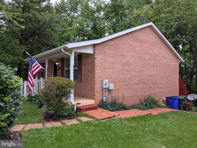 1505 Cedarcrest Ln, Frederick, MD 21702 - view of property exterior with covered porch, a yard, brick siding, and view of wooded area