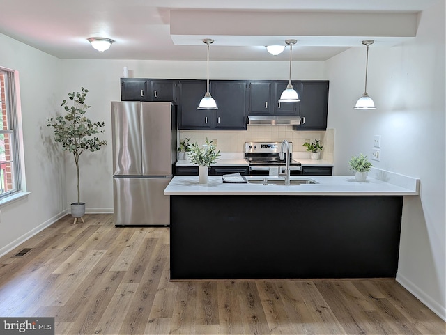 1505 Cedarcrest Ln, Frederick, MD 21702 - kitchen featuring appliances with stainless steel finishes, under cabinet range hood, light countertops, dark cabinetry, and a peninsula