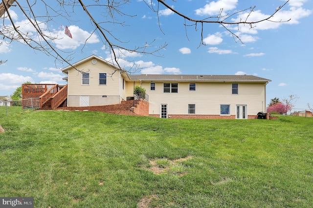back of property with a lawn, a deck, and stairs