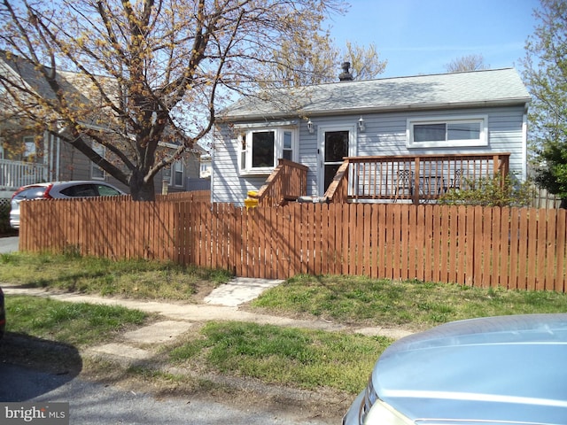 bungalow with roof with shingles and a fenced front yard