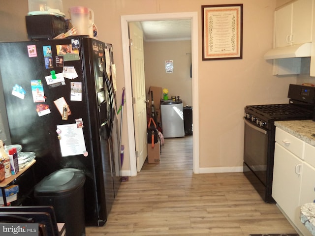 kitchen featuring light wood-style flooring, under cabinet range hood, white cabinetry, and black appliances