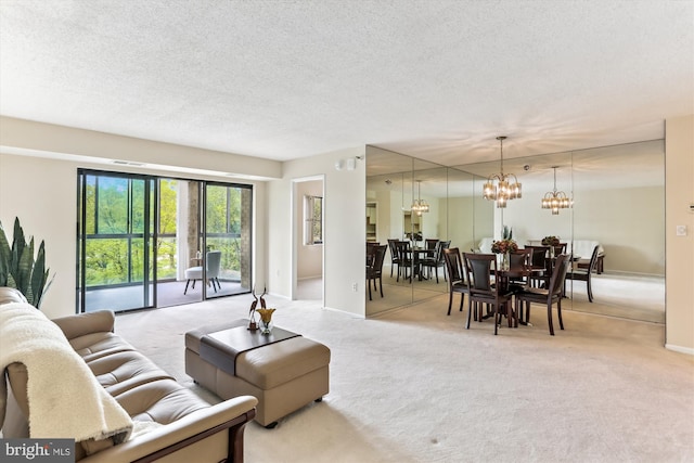 carpeted living room featuring baseboards, a notable chandelier, and a textured ceiling