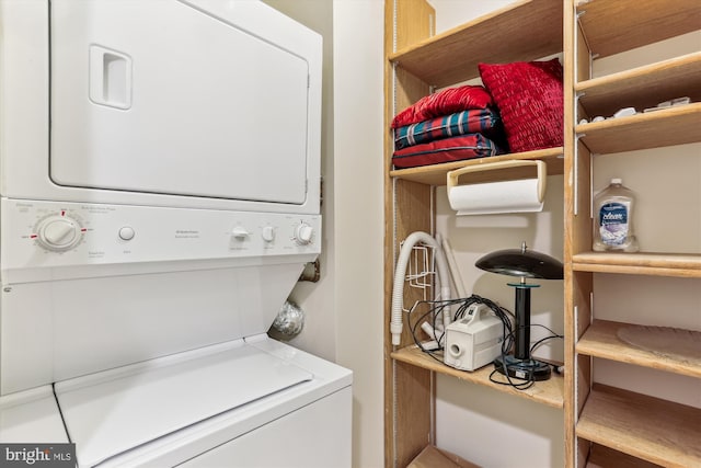 washroom with stacked washing maching and dryer and laundry area