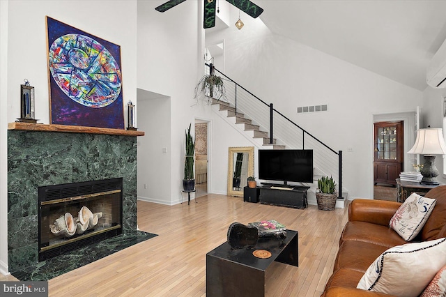 1506 N Bay Shore Dr, Milton, DE 19968 - living area featuring high vaulted ceiling, visible vents, stairway, wood finished floors, and a tile fireplace