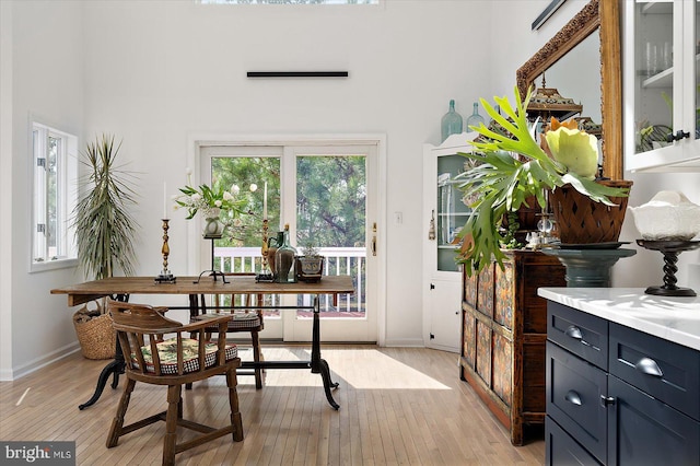 1506 N Bay Shore Dr, Milton, DE 19968 - dining space featuring light wood-style flooring, baseboards, and a high ceiling