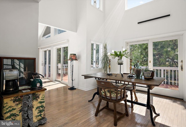 1506 N Bay Shore Dr, Milton, DE 19968 - dining room featuring a wealth of natural light, a towering ceiling, hardwood / wood-style flooring, and baseboards