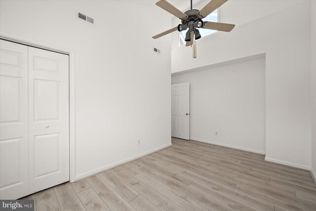 1506 N Bay Shore Dr, Milton, DE 19968 - unfurnished bedroom featuring visible vents, baseboards, a closet, a high ceiling, and wood finished floors