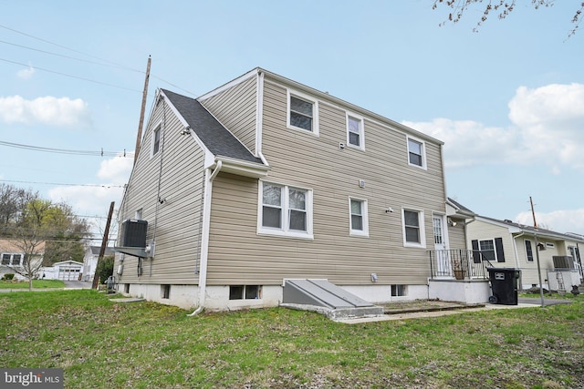 2175 Princeton Pike, Lawrenceville, NJ 08648 - back of property featuring roof with shingles, a yard, and central AC